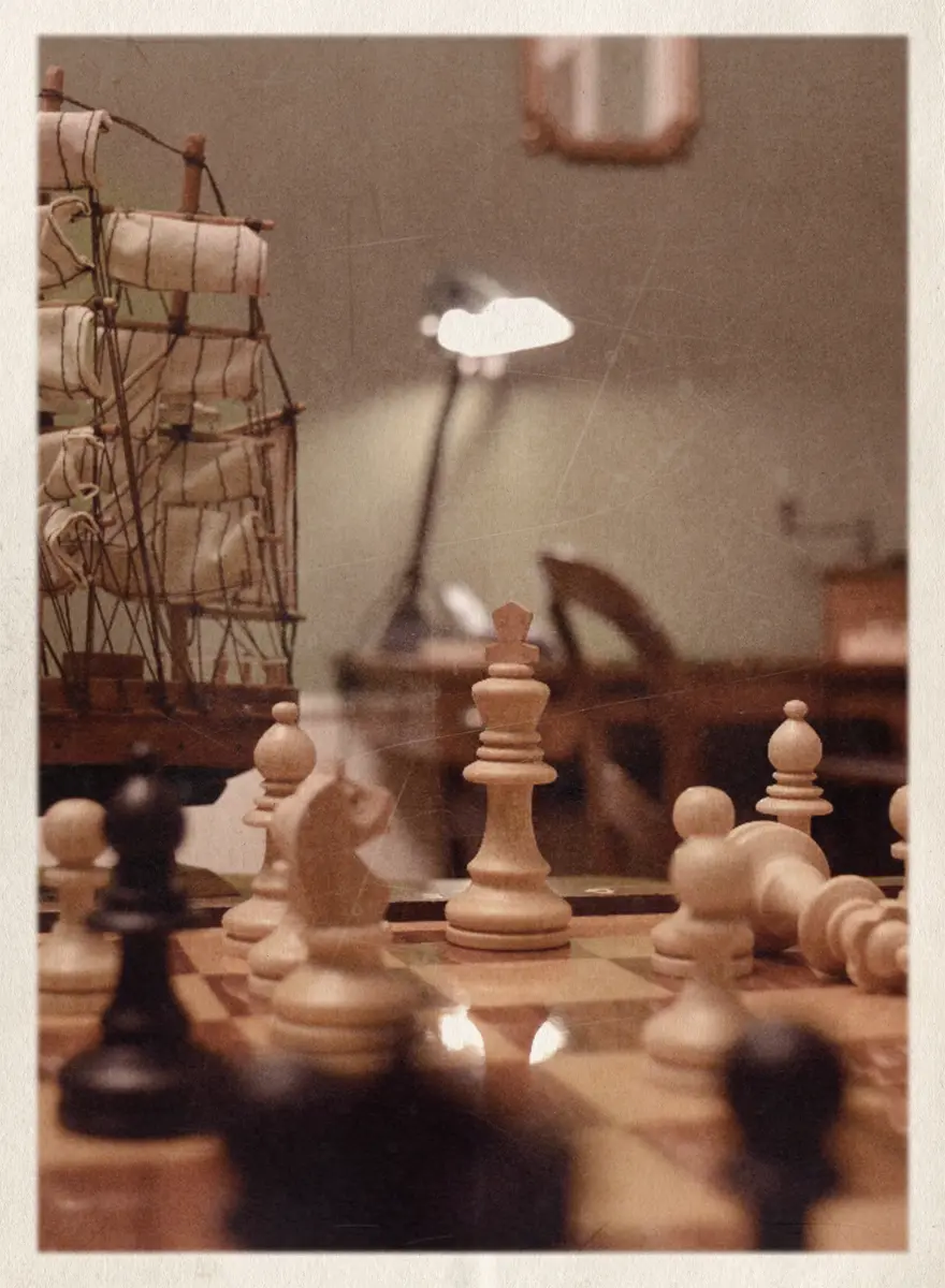 Jeu d'échec et maquette de bateau sur un bureau